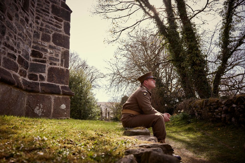 Tristan sitting on a bench in his army uniform.