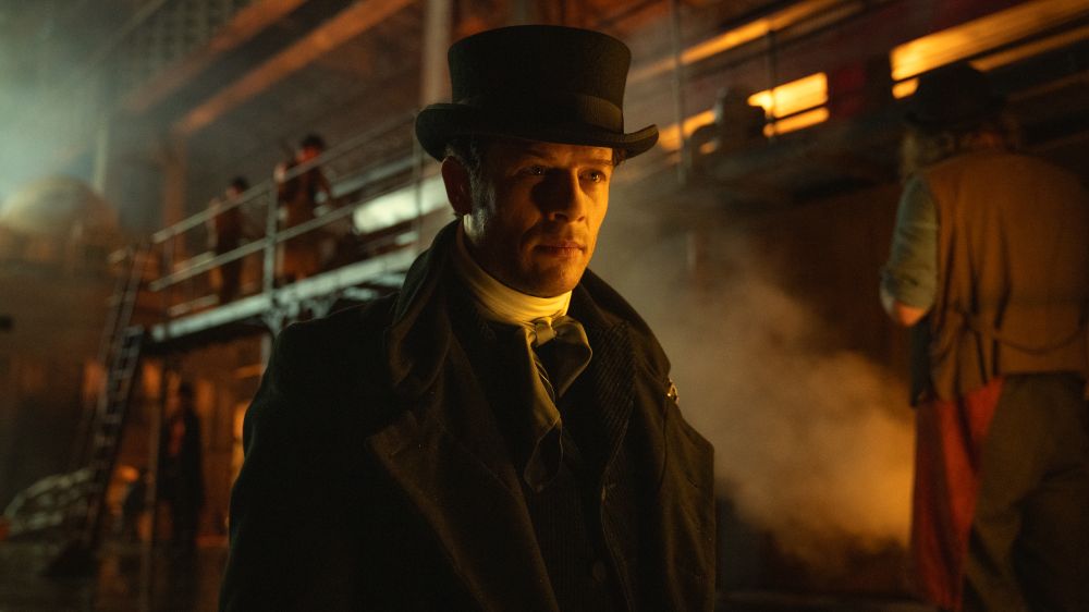 Sean wearing a top hat in a dark place. 