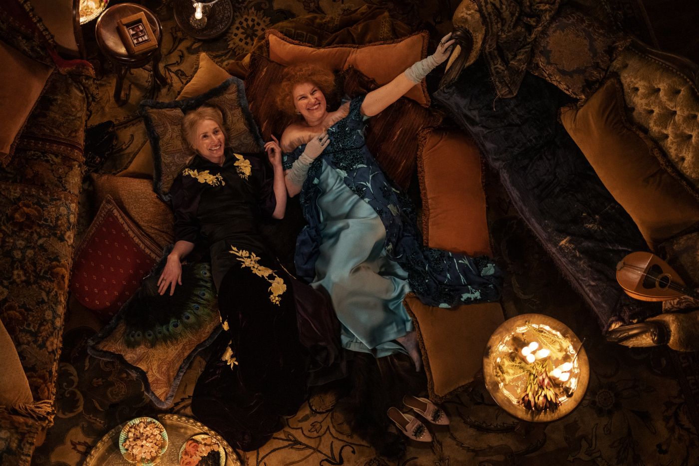 Augusta Beecham and Helen Bossier lying together on a sofa during the New Year’s Eve party in My Brilliant Career Episode 4.