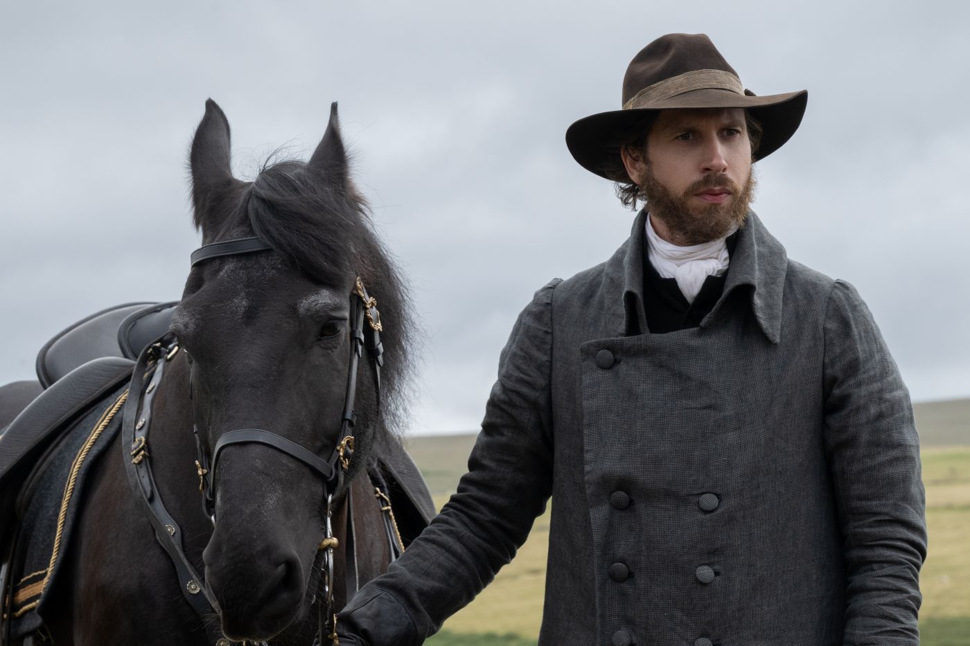 Herbert Nordrum as Colonel Brandon standing beside a black horse in Sense and Sensibility.