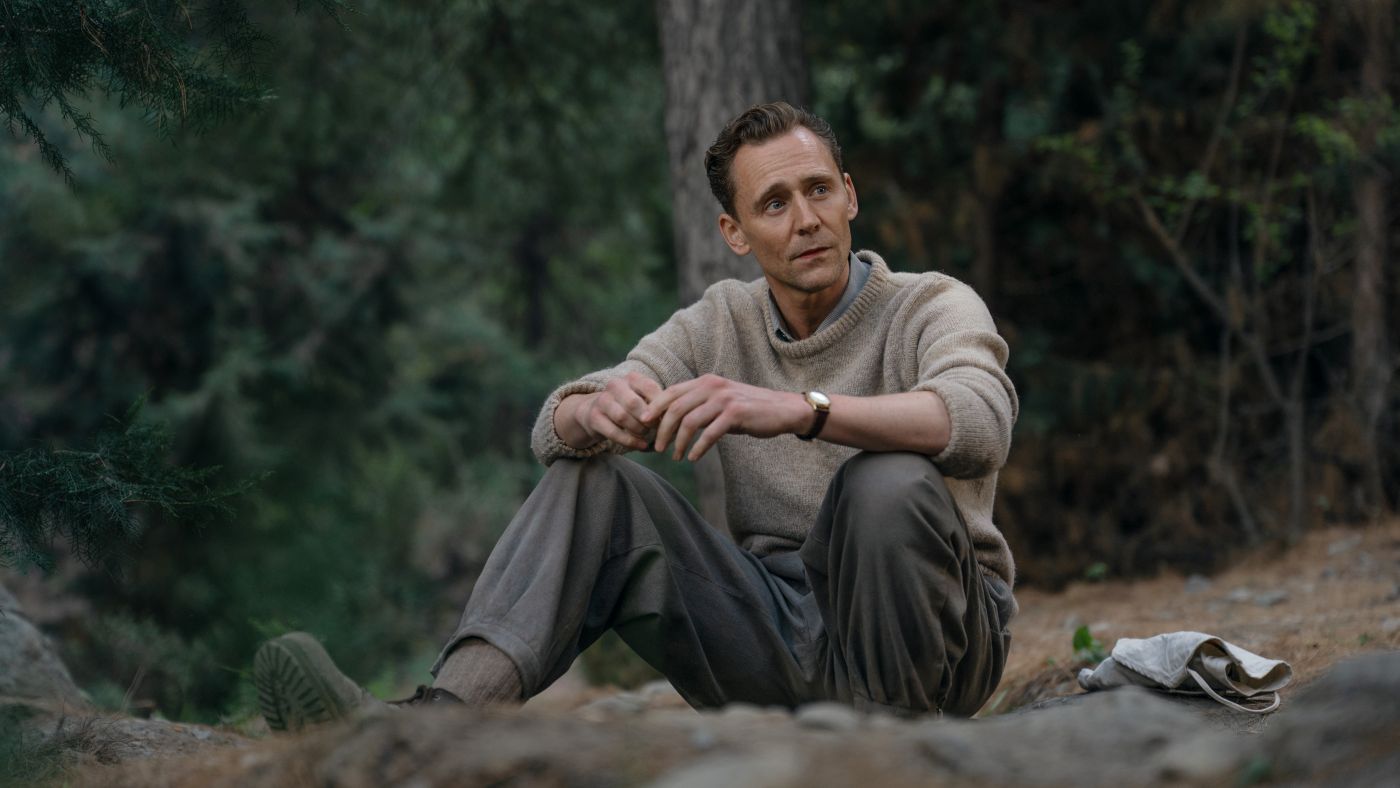 Tom Hiddleston as Edmund Hillary sitting outdoors in Tenzing.