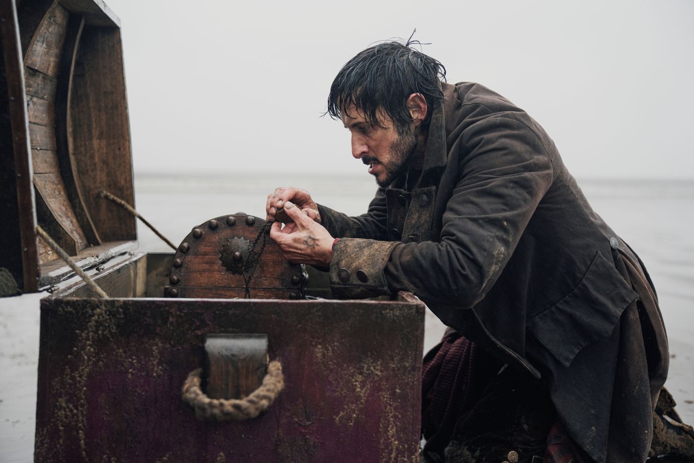 Tomer Capone as Billy Bones with a sea chest in Treasure Island